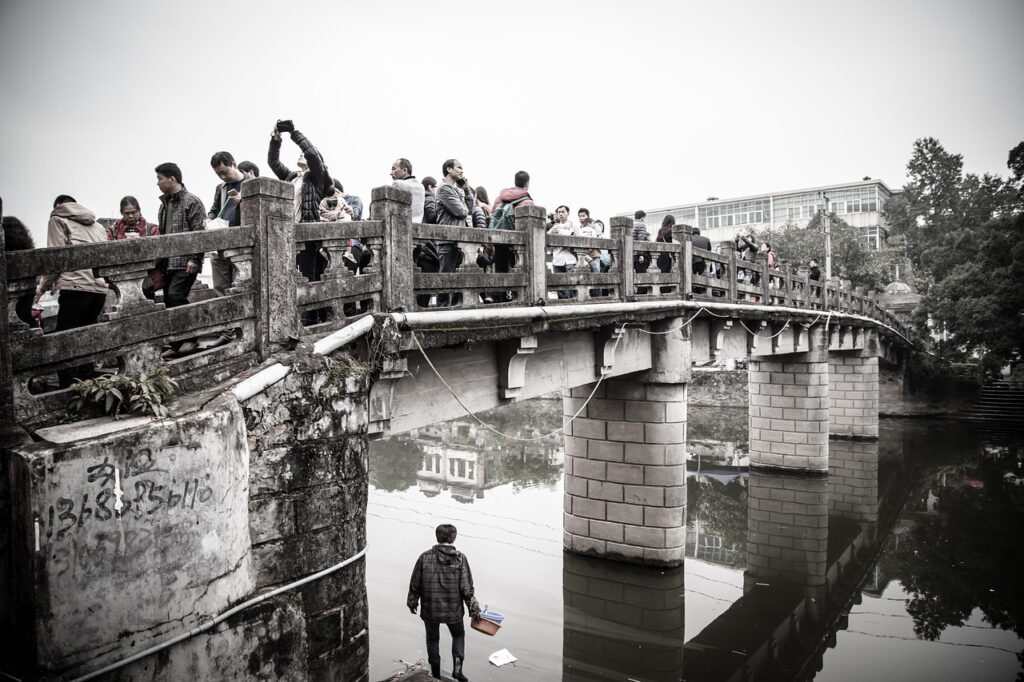 Photo of a diverse crowd of people crossing a bridge to symbolise civil society bridging the divides