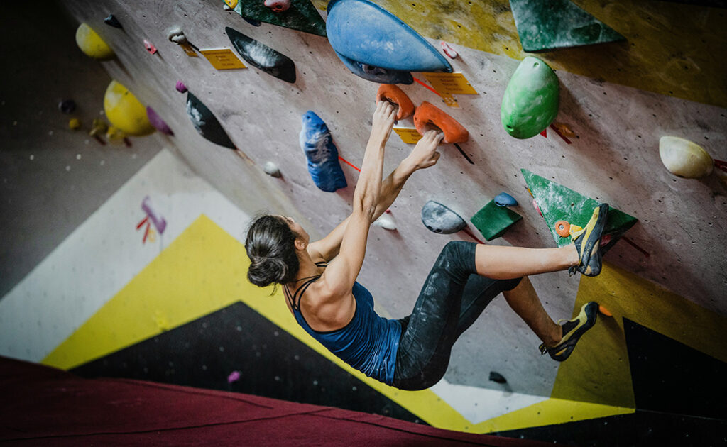 Resilience - photo of a woman climbing an indoor climbing wall taken from above