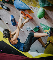 Resilience - photo of a woman climbing an indoor climbing wall taken from above