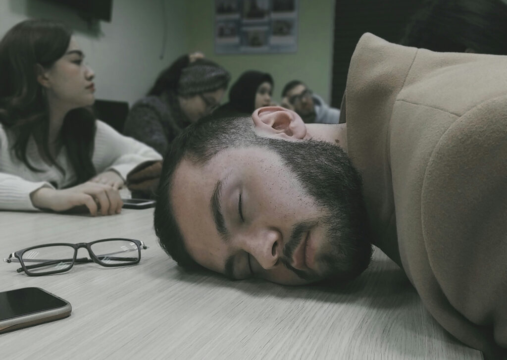 The team delusion - a photo of a meeting with one person falling asleep and others distracted